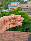 Elegant Oxidized Gold Stone-Studded Jhumka Earrings - Red